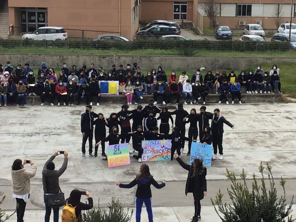Sopra: la manifestazione all'Alberghiero. Sotto il titolo: lo "Sturzo" illuminato con i colori della bandiera dell'Ucraina