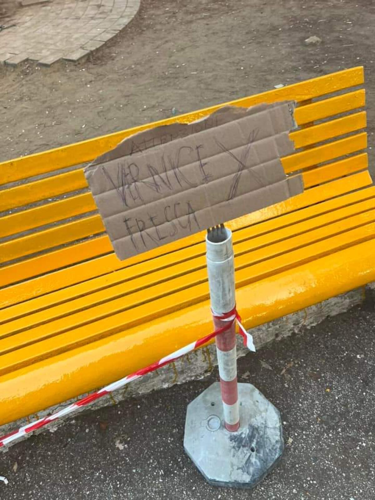 Panchina dipinta con il fai da te e l’avviso di vernice fresca -